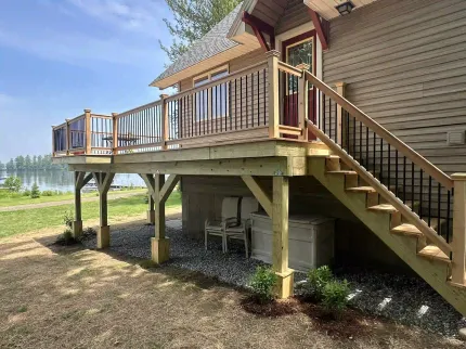 A house with a large deck and stairs leading up to it.