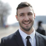 A man in a suit and tie is smiling for the camera.