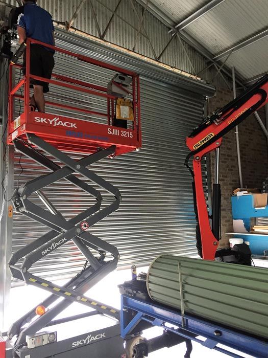 worker installing garage door