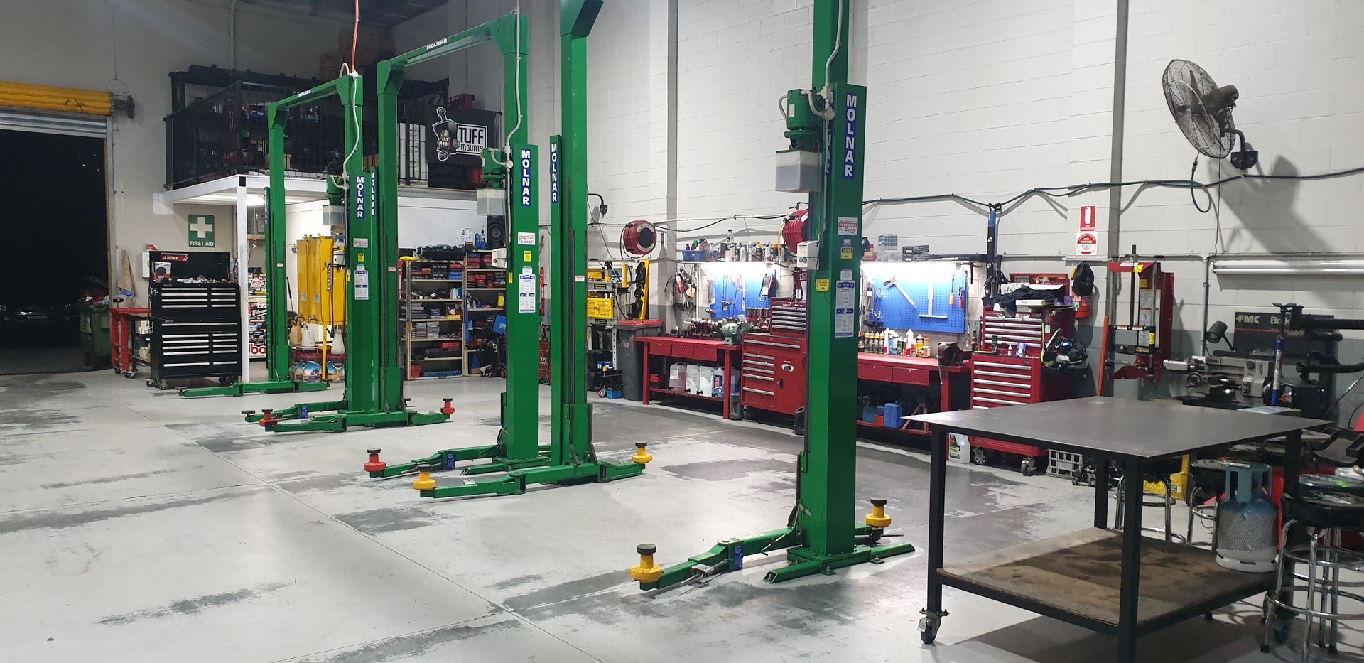 A car repair shop with green lifts and various tools and equipment — Cartech Australia in Wodonga, NSW