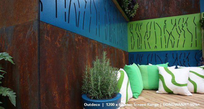 A potted plant sits in front of a wall with a blue and green design on it