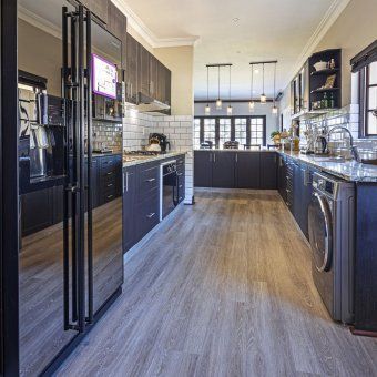 A kitchen with stainless steel appliances and wooden floors.