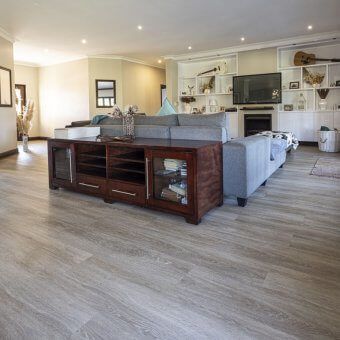 A living room with hardwood floors , a couch , a television and a fireplace.