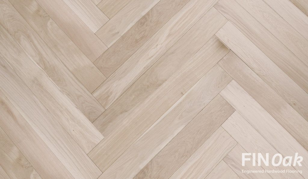 A close up of a wooden floor with a herringbone pattern.