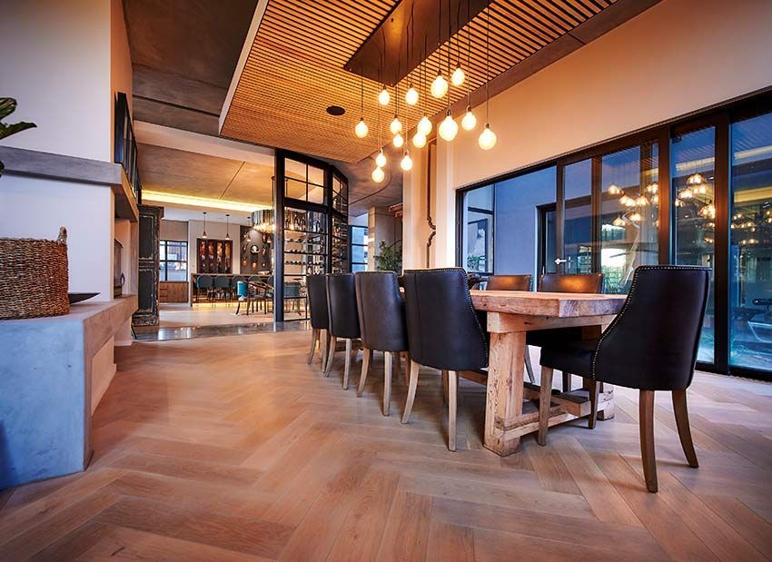 A dining room with a long wooden table and chairs.