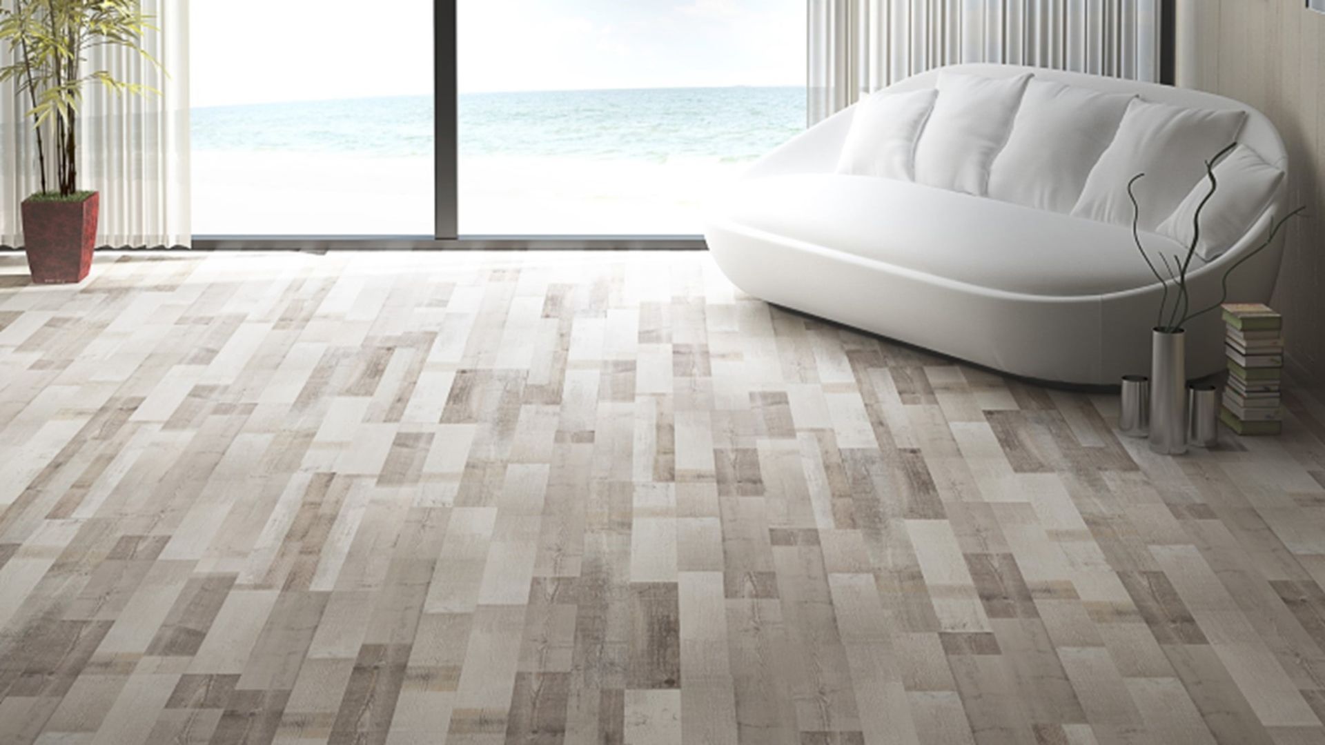 A living room with a couch and a large window overlooking the ocean.