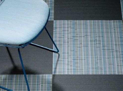 A blue chair is sitting on a blue and black checkered floor.