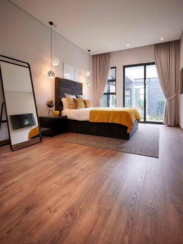 A bedroom with a large bed and a large mirror.