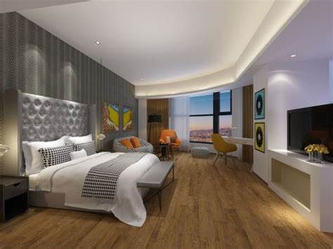 A hotel room with a large bed , chairs , television and a large window.