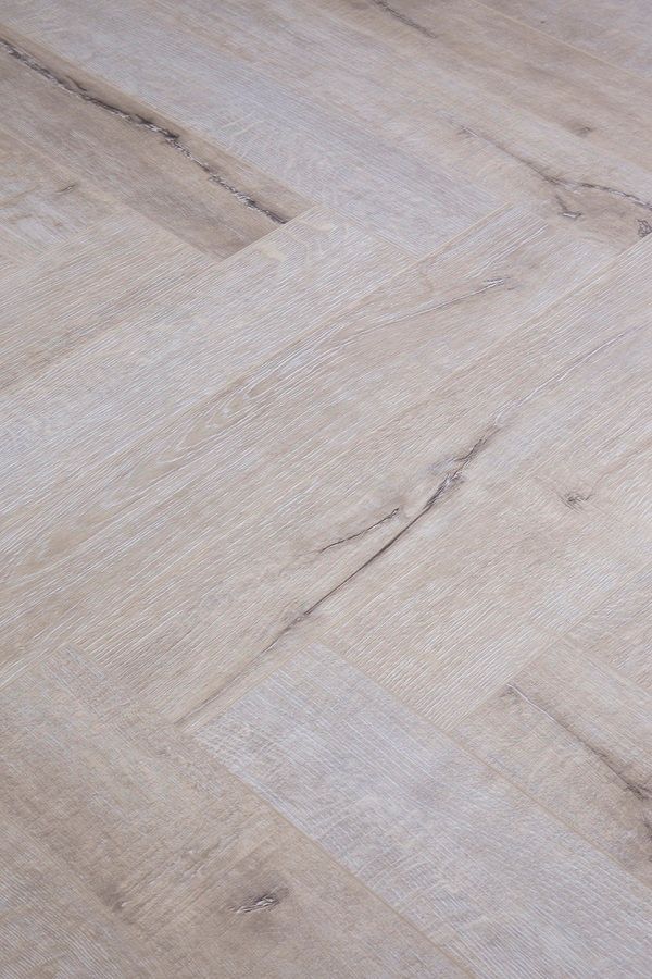A close up of a wooden floor with a herringbone pattern.