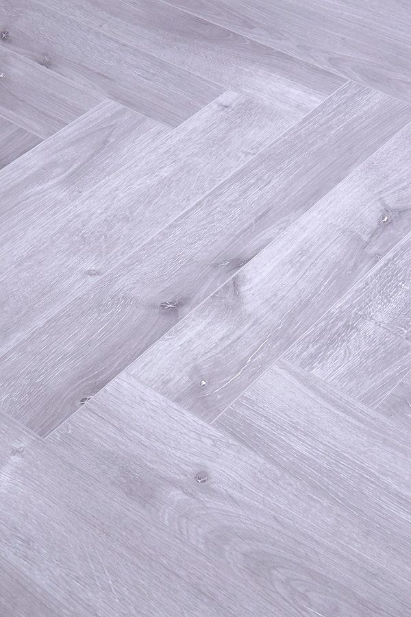 A close up of a gray wooden floor with a herringbone pattern.