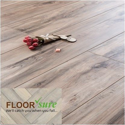 A bouquet of flowers is laying on a wooden floor.