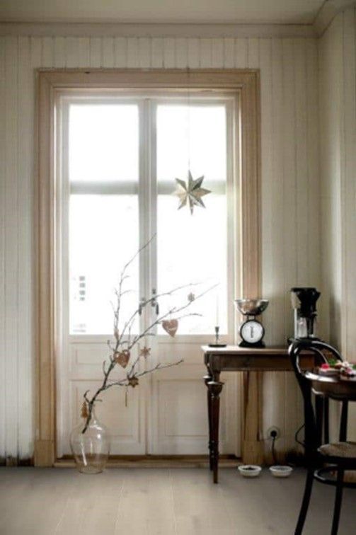 A room with a table and chairs in front of a window.
