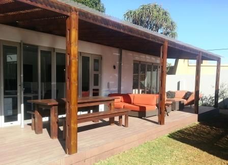 A patio with a couch and a table under a canopy