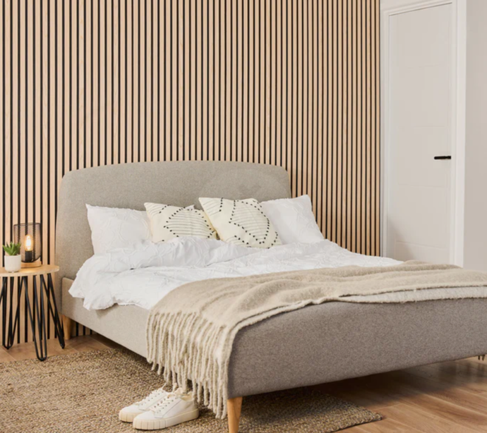 A bedroom with a bed and a striped wall