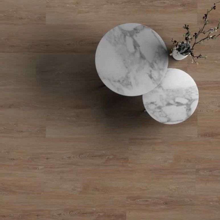 Two marble tables on a wooden floor with a vase of flowers on them