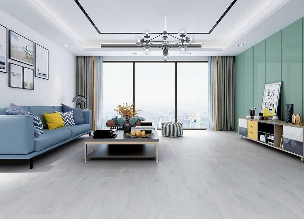 A living room with a blue couch , a coffee table , and a large window.