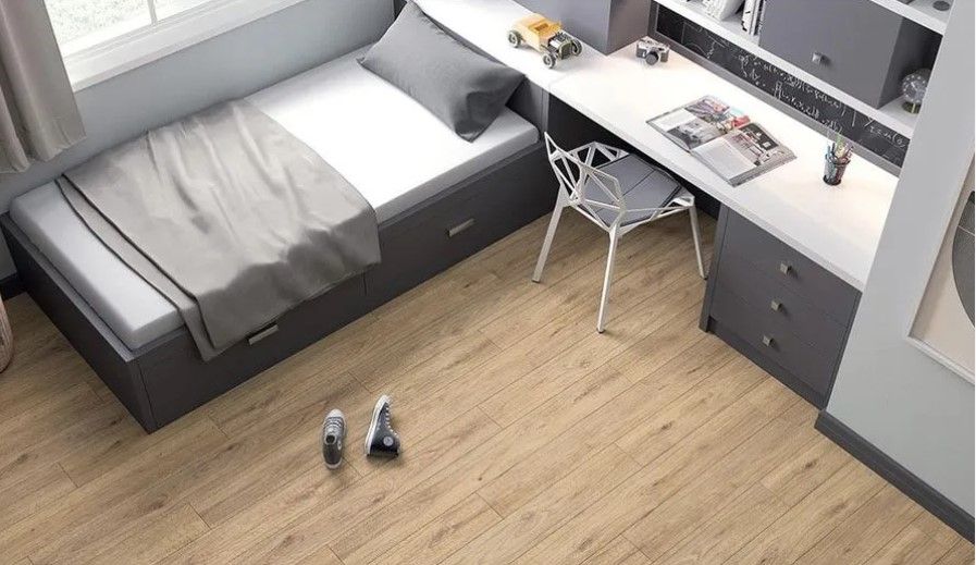 A bedroom with a bed , desk and chair.