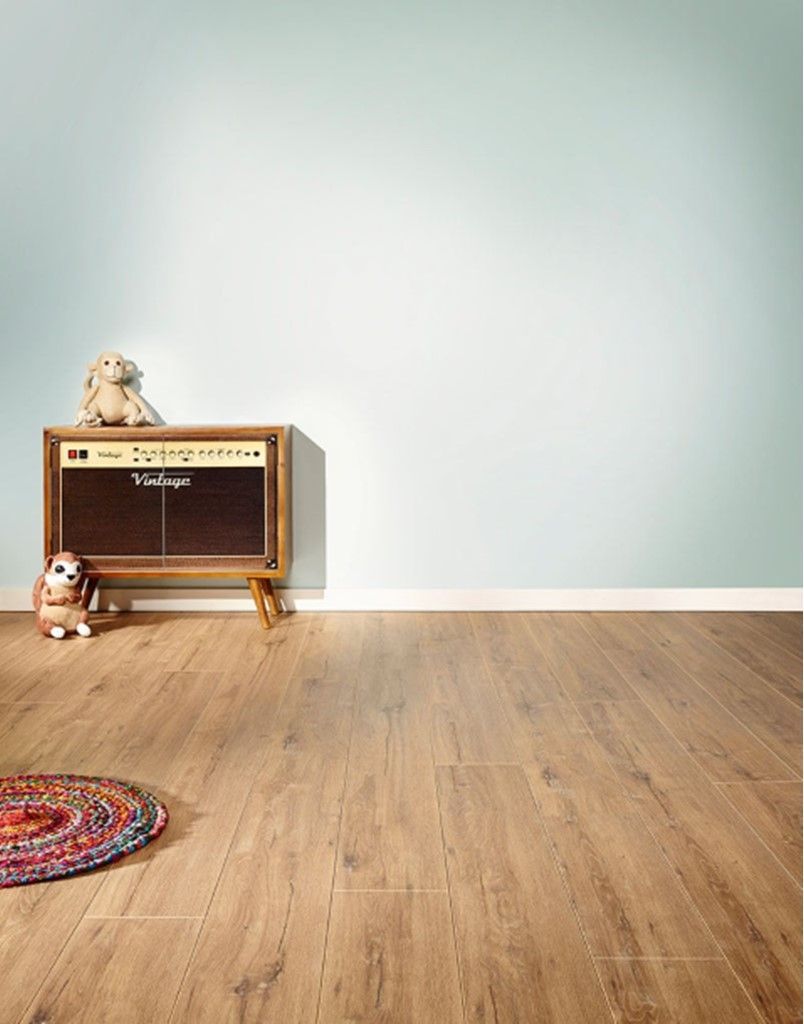 A room with a wooden floor a teddy bear and an amplifier