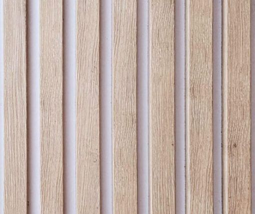 A close up of a row of wooden sticks on a white surface.