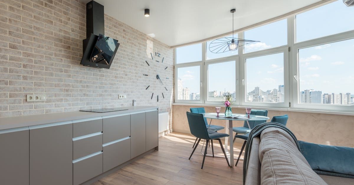 A kitchen with a dining table and chairs and a large window.