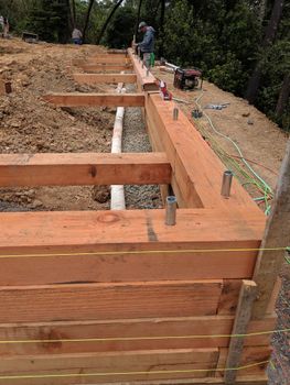A wooden fence is being built on top of a dirt hill.