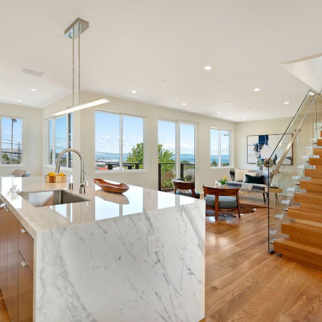 A kitchen with a marble counter top and stairs