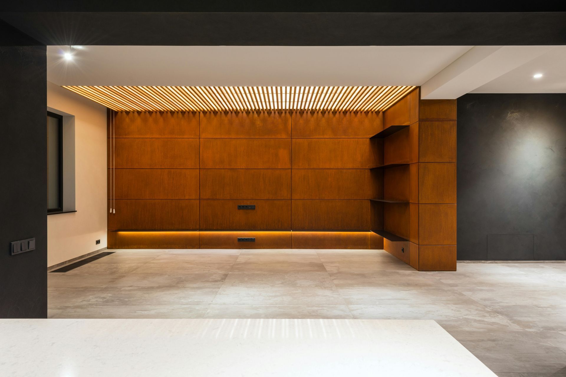 An empty room with a wooden wall and a concrete floor.