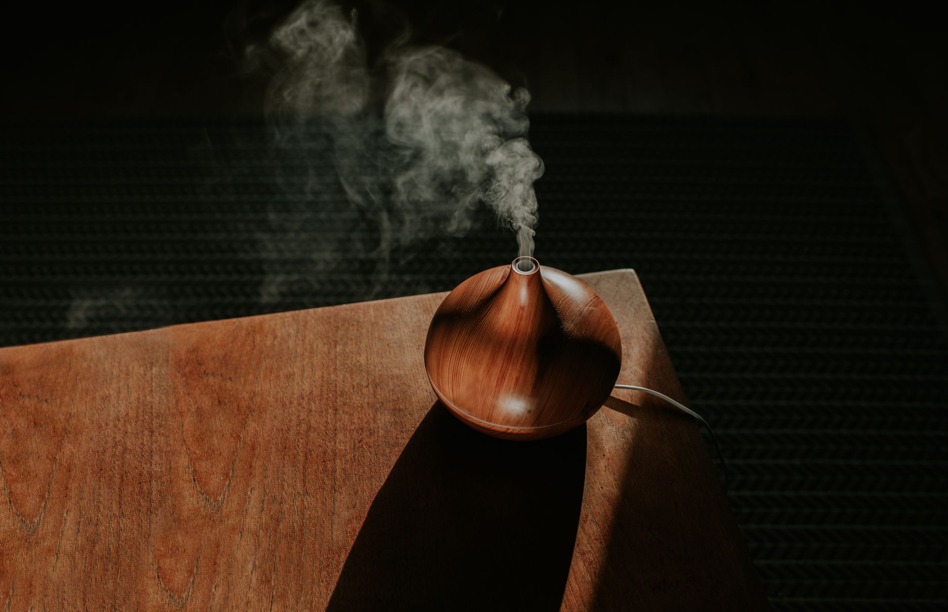 Wooden essential oil diffuser emitting vapor on a wooden surface - Thames, NZ - Thai Classic Massage Thames