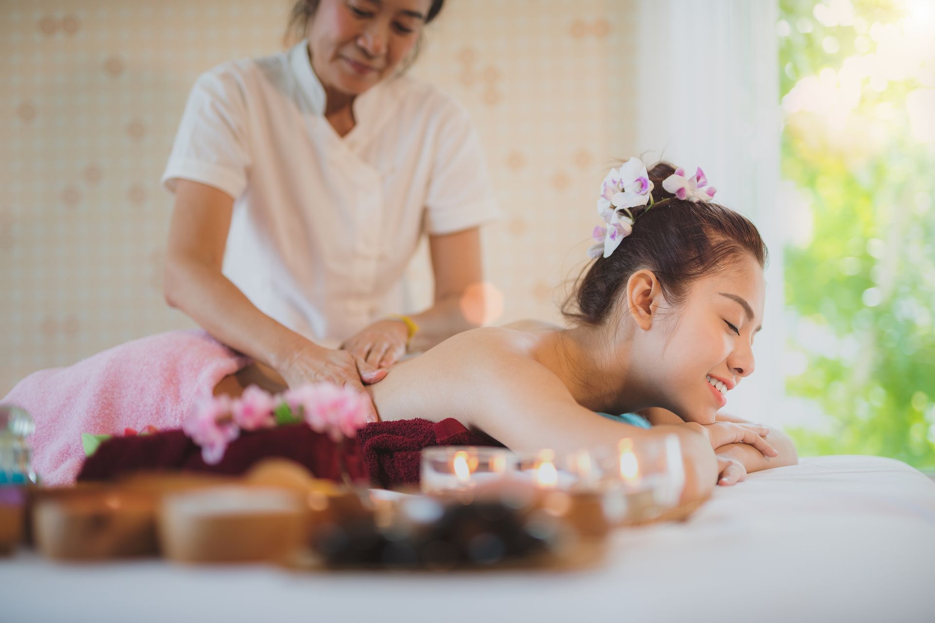 Woman receiving back massage from a masseuse in a spa-like setting - Thames, NZ - Thai Classic Massage Thames