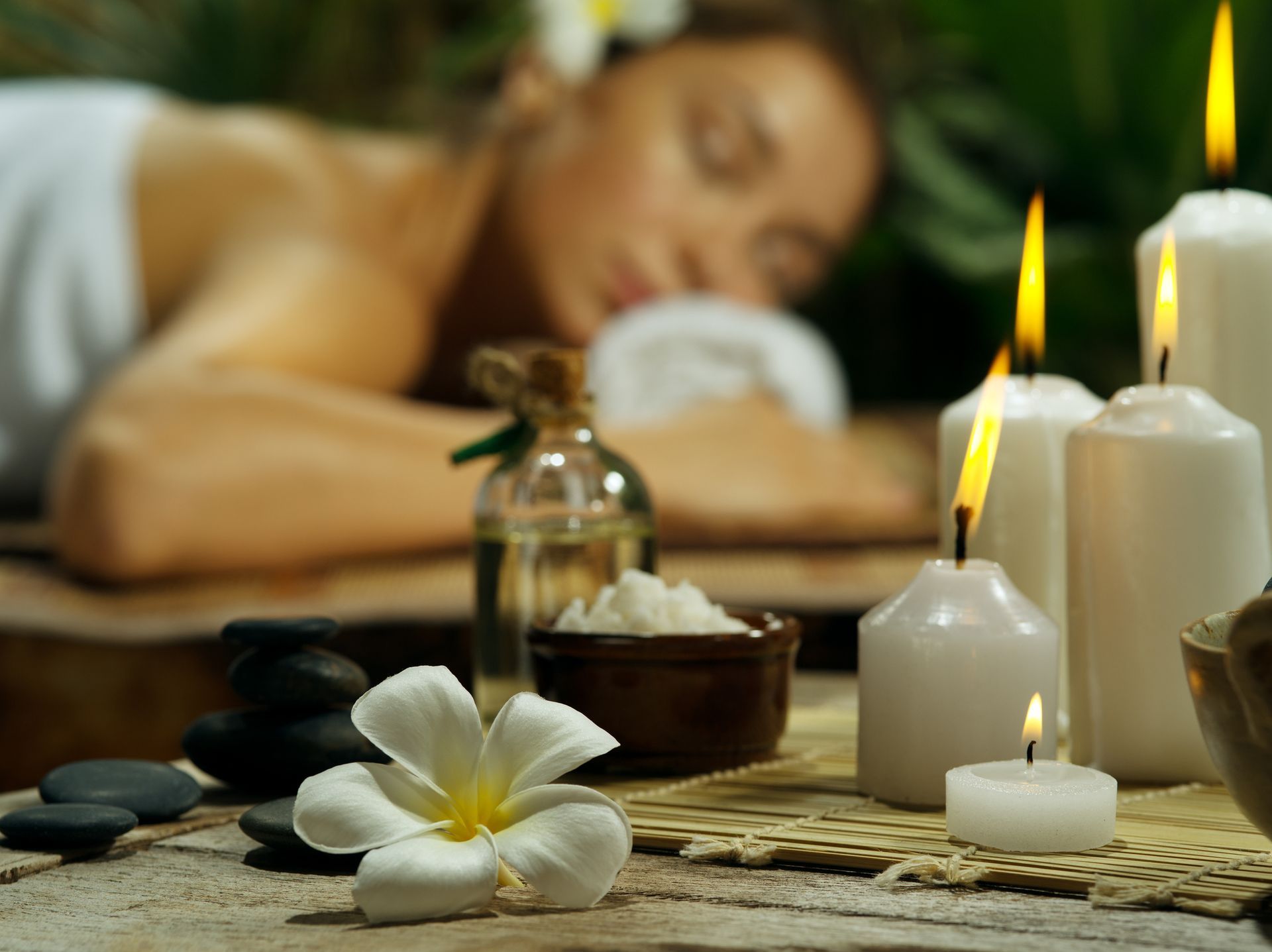 Woman receiving a massage in a spa setting, with candles, flower, and oil, creating a relaxing atmosphere - Thames, NZ - Thai Classic Massage Thames