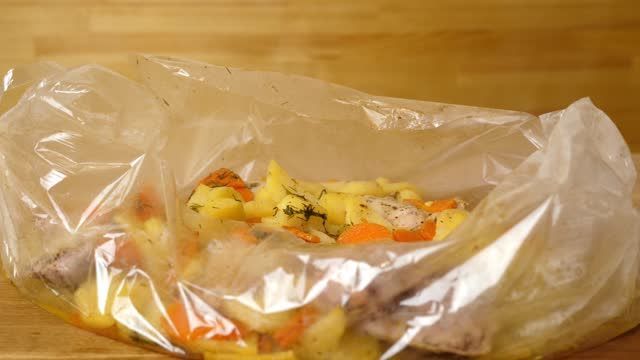 A plastic bag filled with potatoes and carrots on a wooden table.