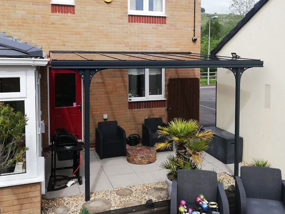 A patio with chairs and a table in front of a house
