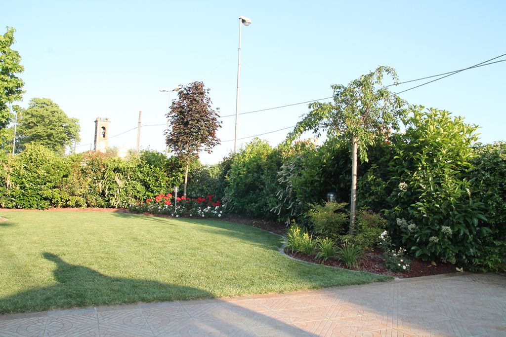 giardino interno di una villa con fiori e alberi