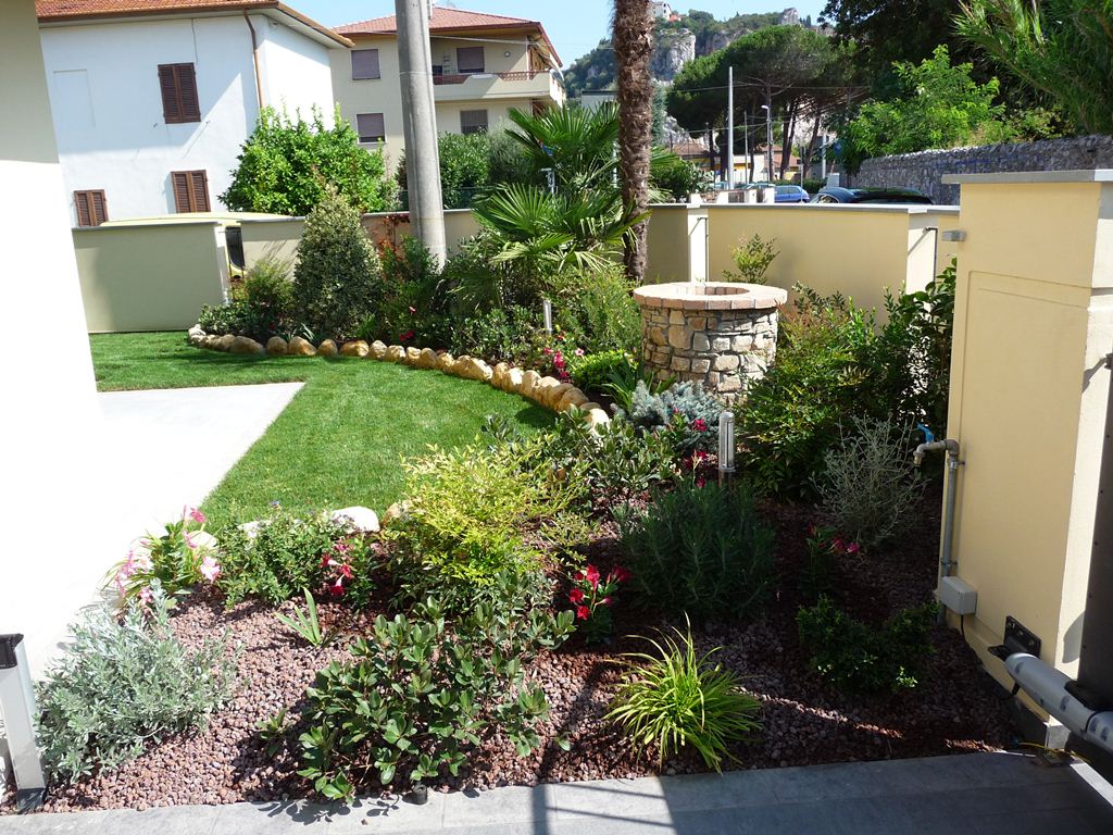 casa con aiuola e pozzo in muratura