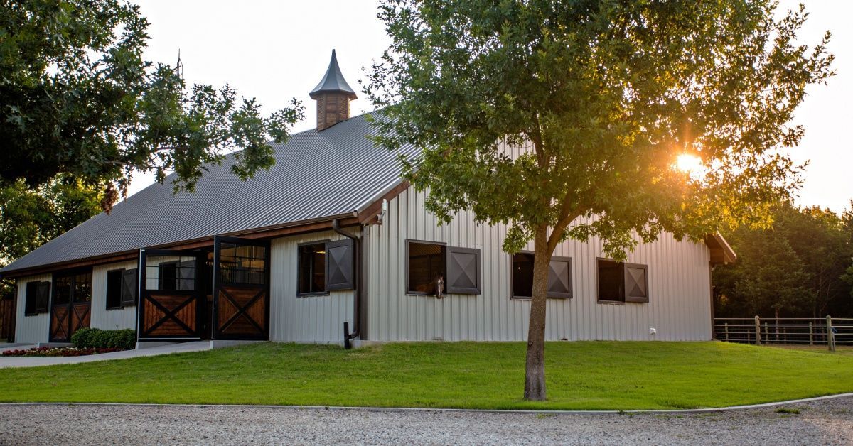 A metal barn with a sloped roof and small windows.