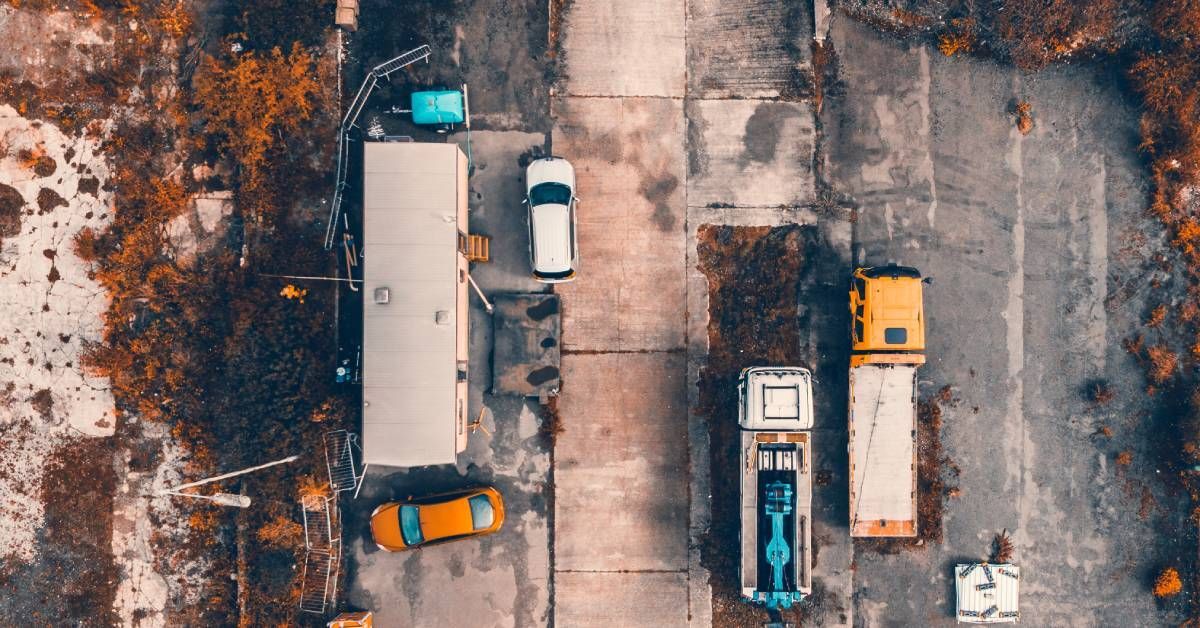 An aerial view of a construction site with vehicles and construction equipment parked in the surrounding area.