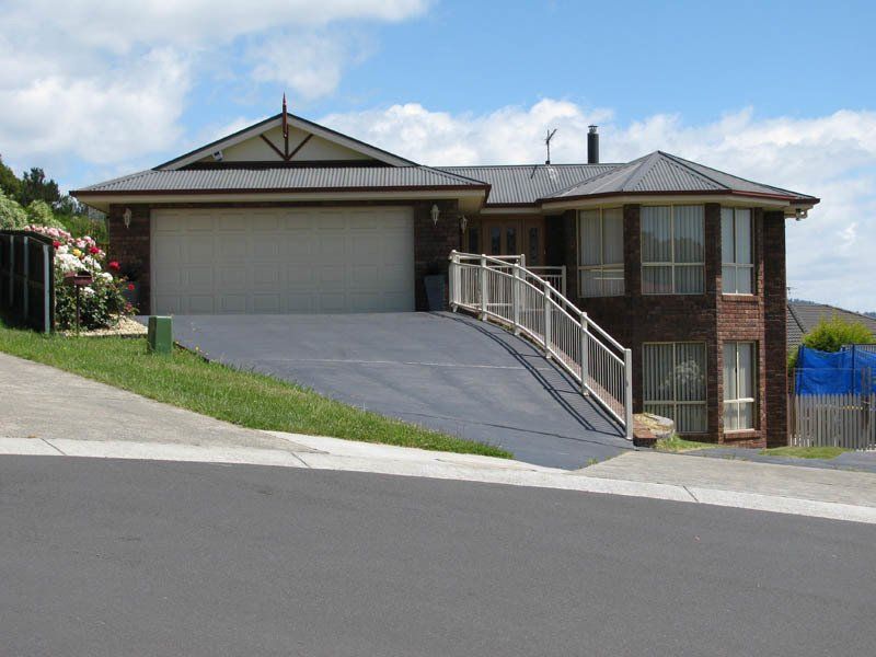 red brick home with sloped driveway