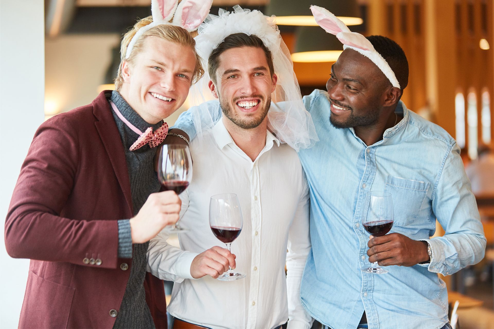 Three men smiling and holding wine glasses.