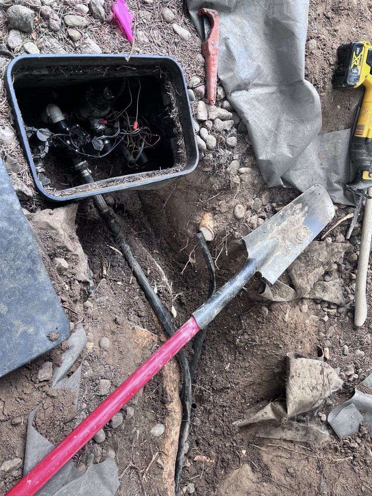 A shovel is laying on the ground next to a box.