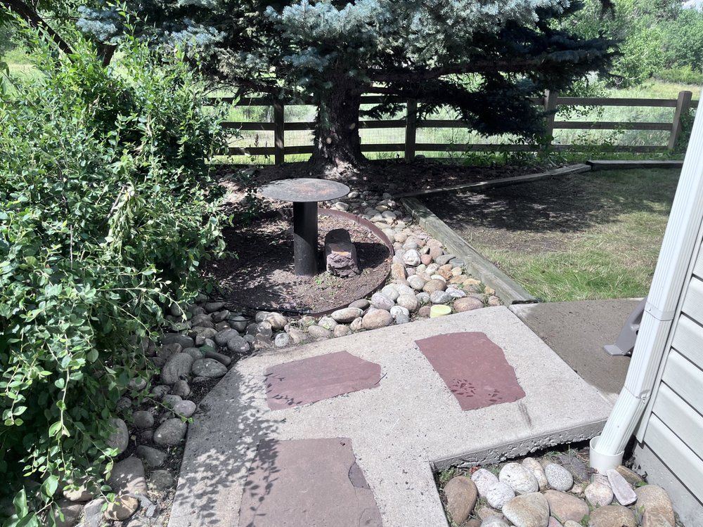 A stone walkway leading to a fenced in yard