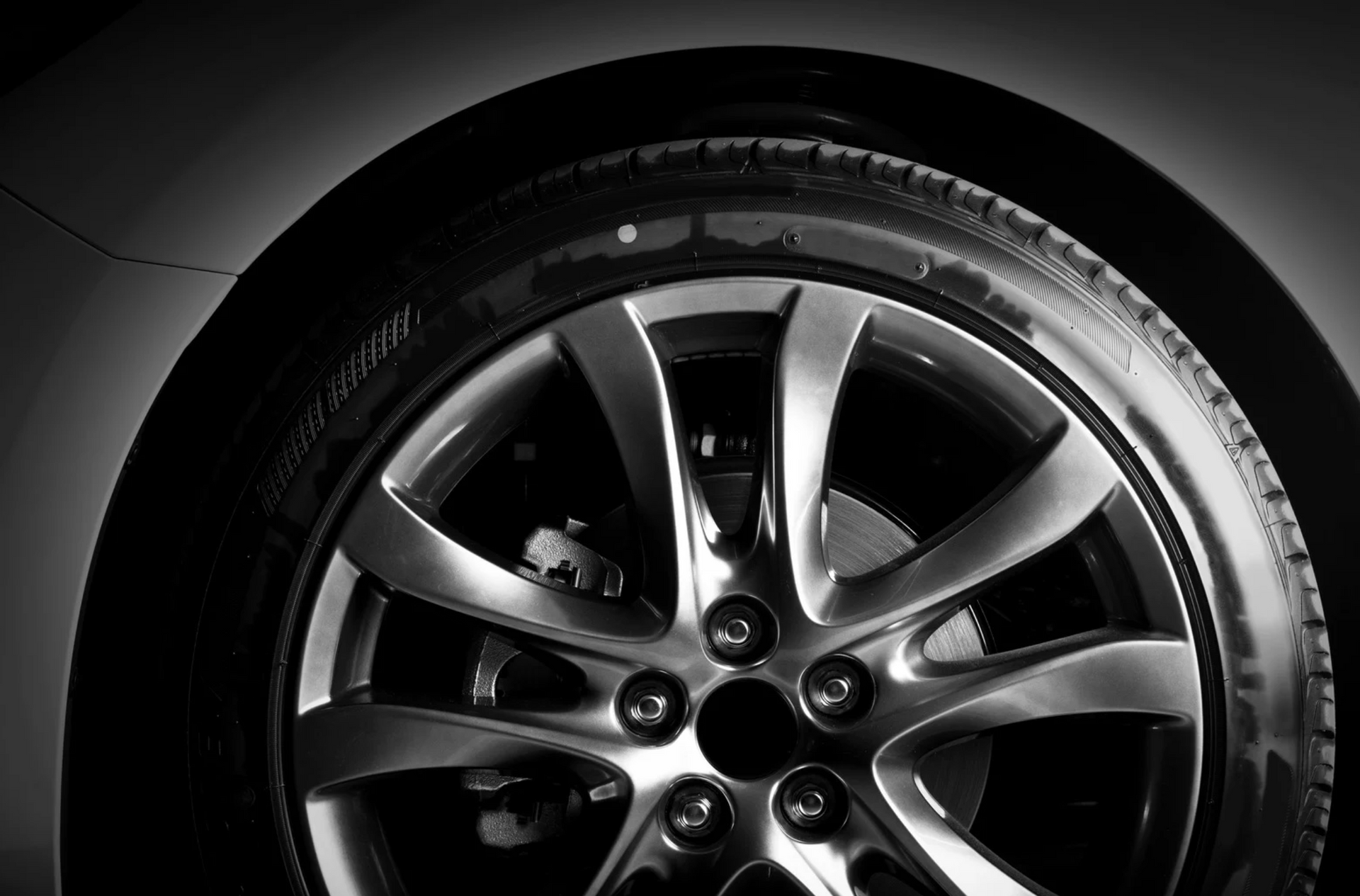 Car tire and alloy wheel in black and white.