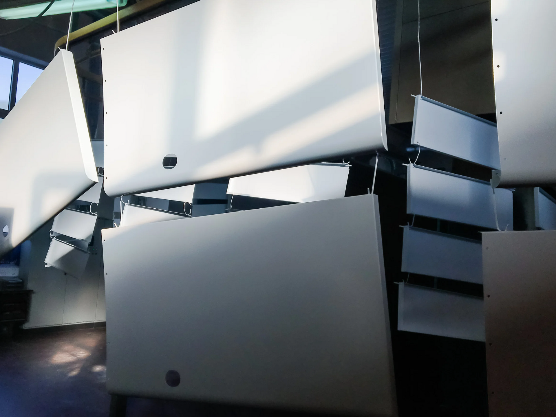 White painted cabinet doors hanging on a production line.