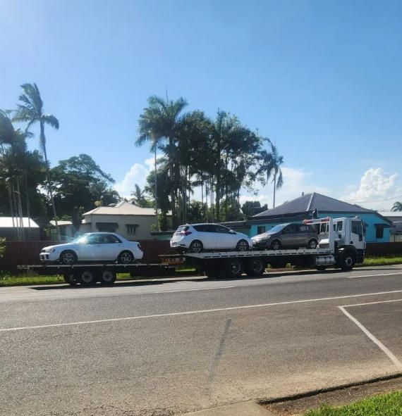 A Tow Truck With Two Cars on the Back of It — Johnson River Towing In Innisfail, QLD