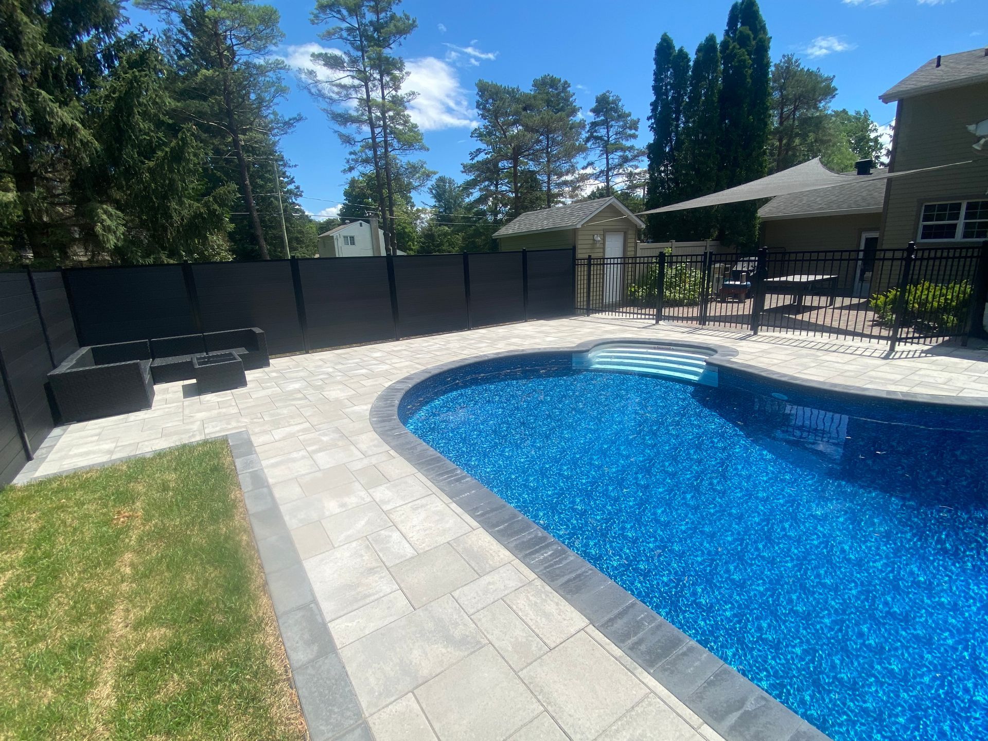 Il y a une grande piscine dans l'arrière-cour d'une maison.