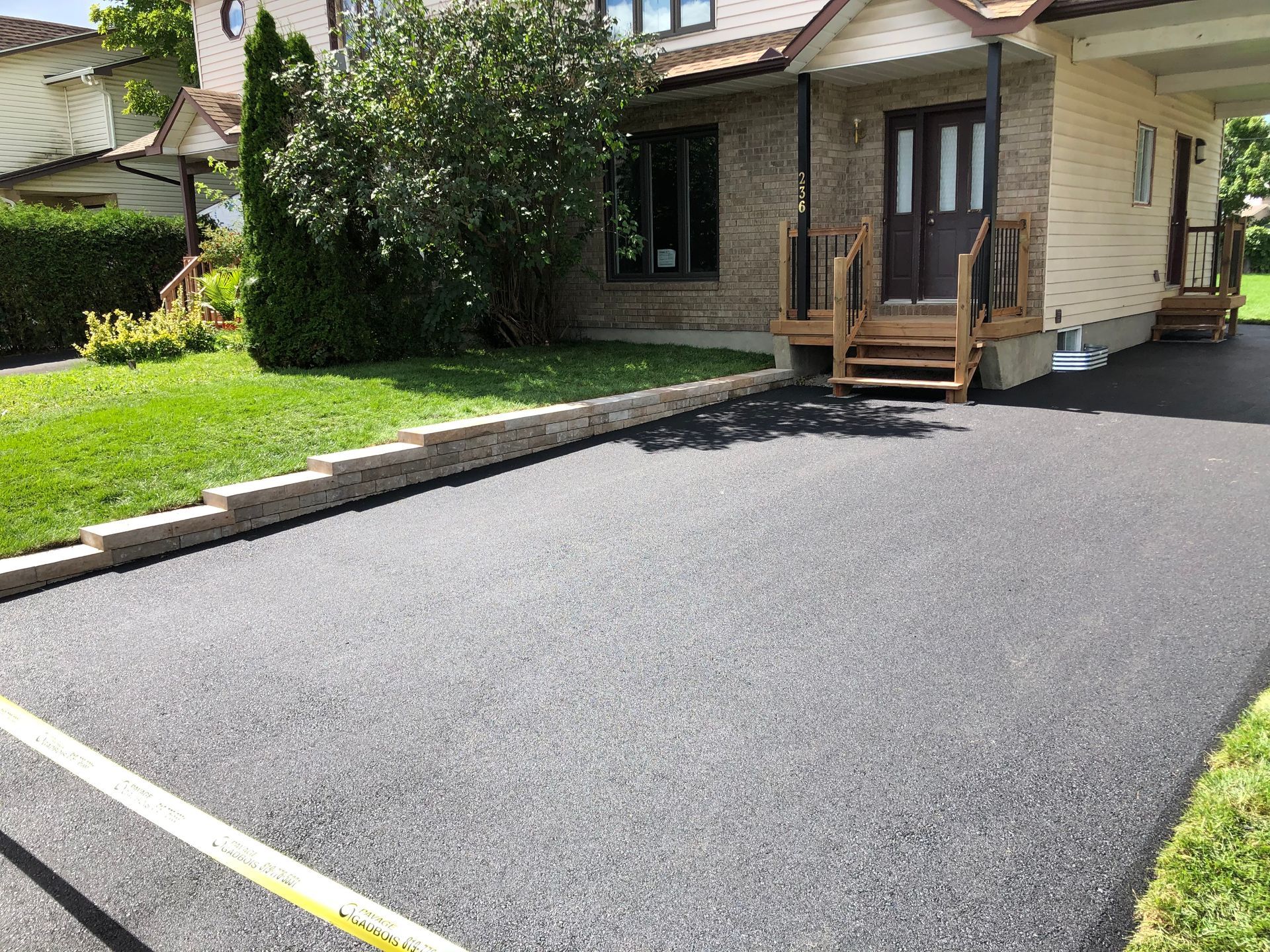 Une allée devant une maison avec un ruban à mesurer jaune.