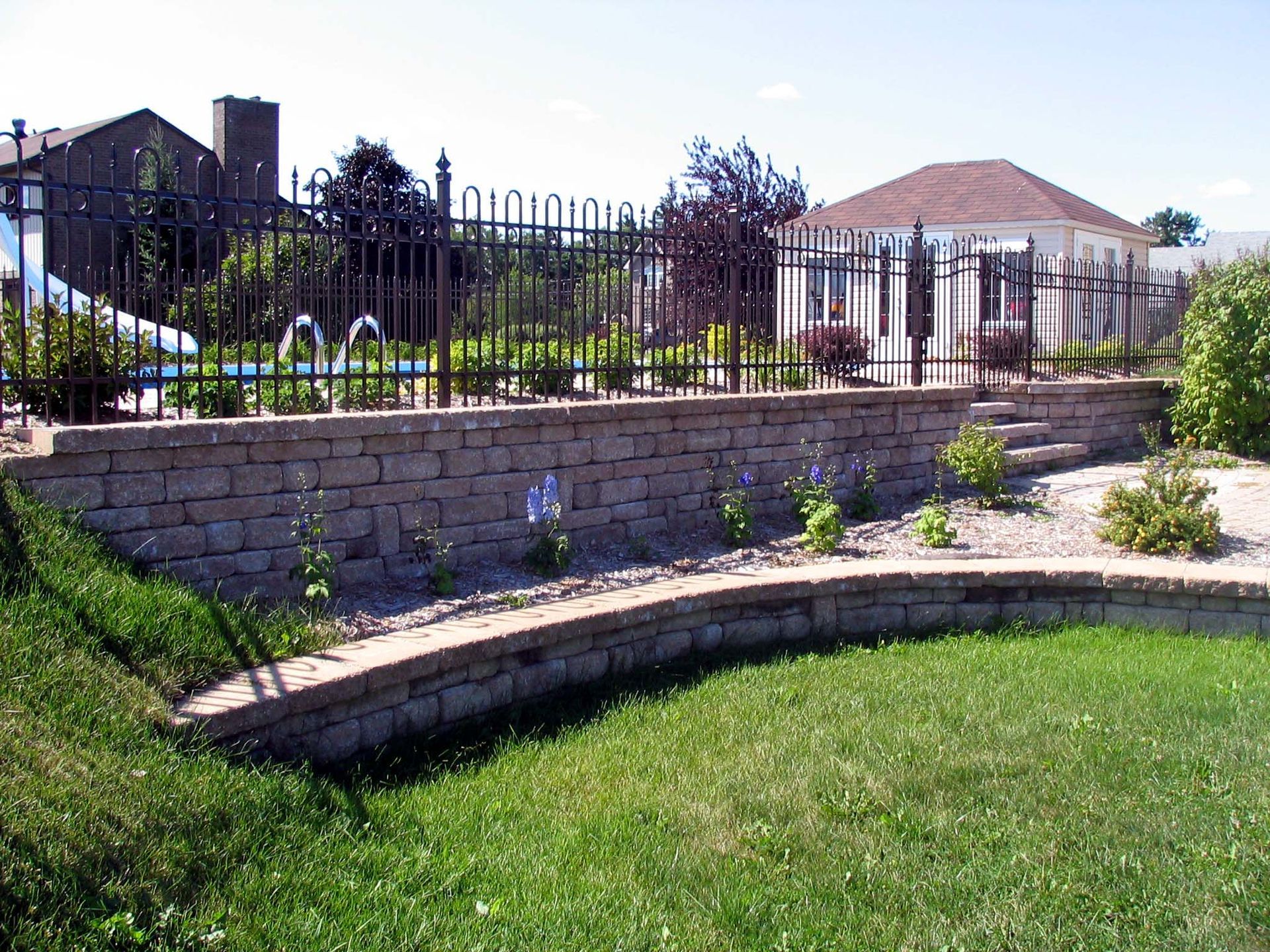 Un mur de briques entouré d'une clôture métallique