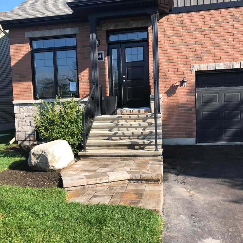 Une maison en briques avec des escaliers menant à la porte d'entrée