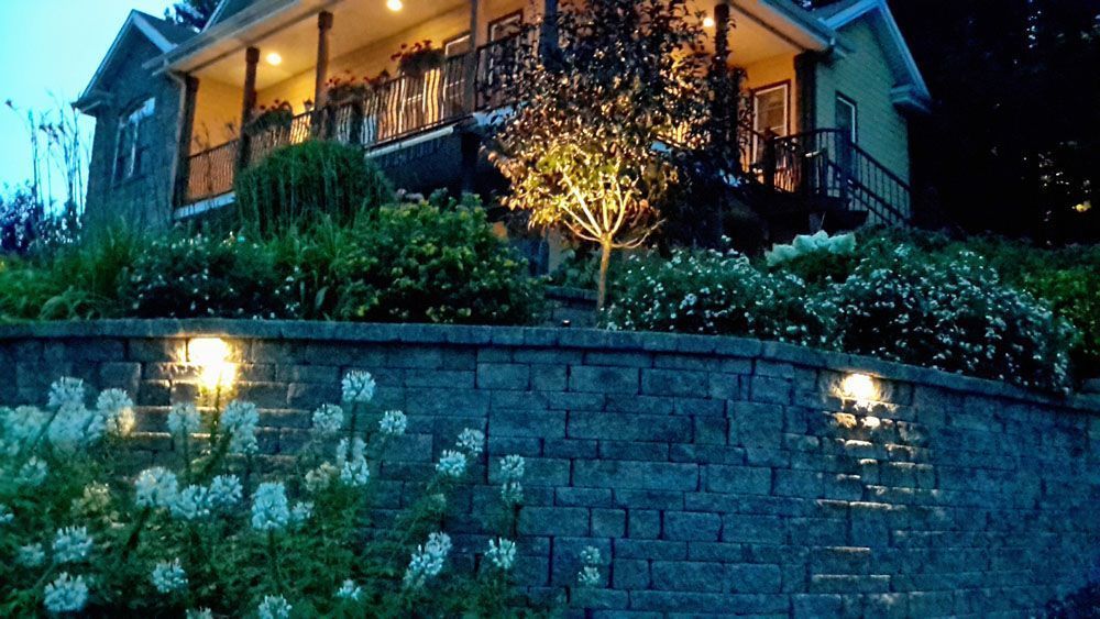 Une grande maison est située au sommet d'une colline la nuit.