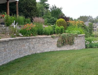 A brick wall surrounds a lush green lawn